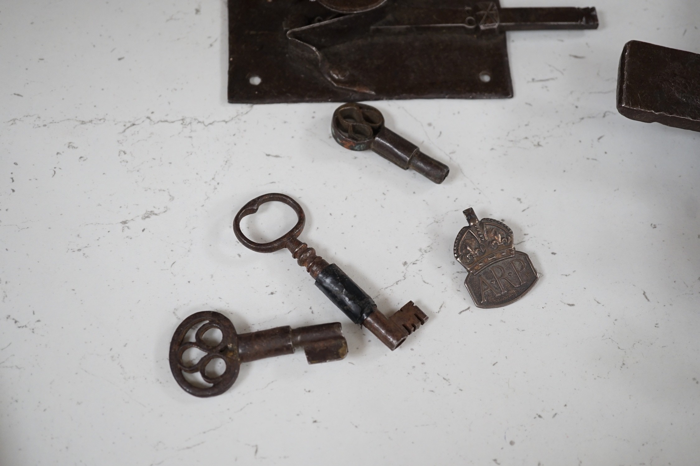 Three early ironwork lock plates with keys and a carved hardwood bolting lock